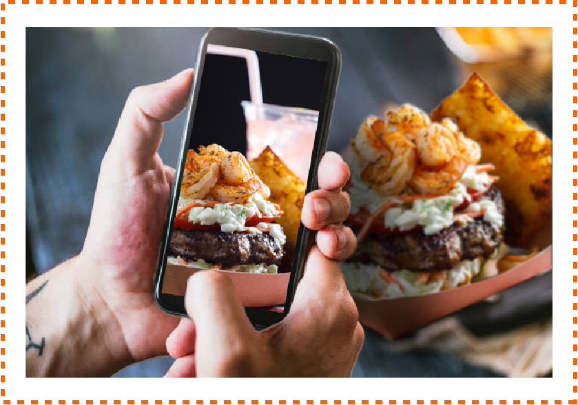 Person taking a picture of a burger with their mobile phone